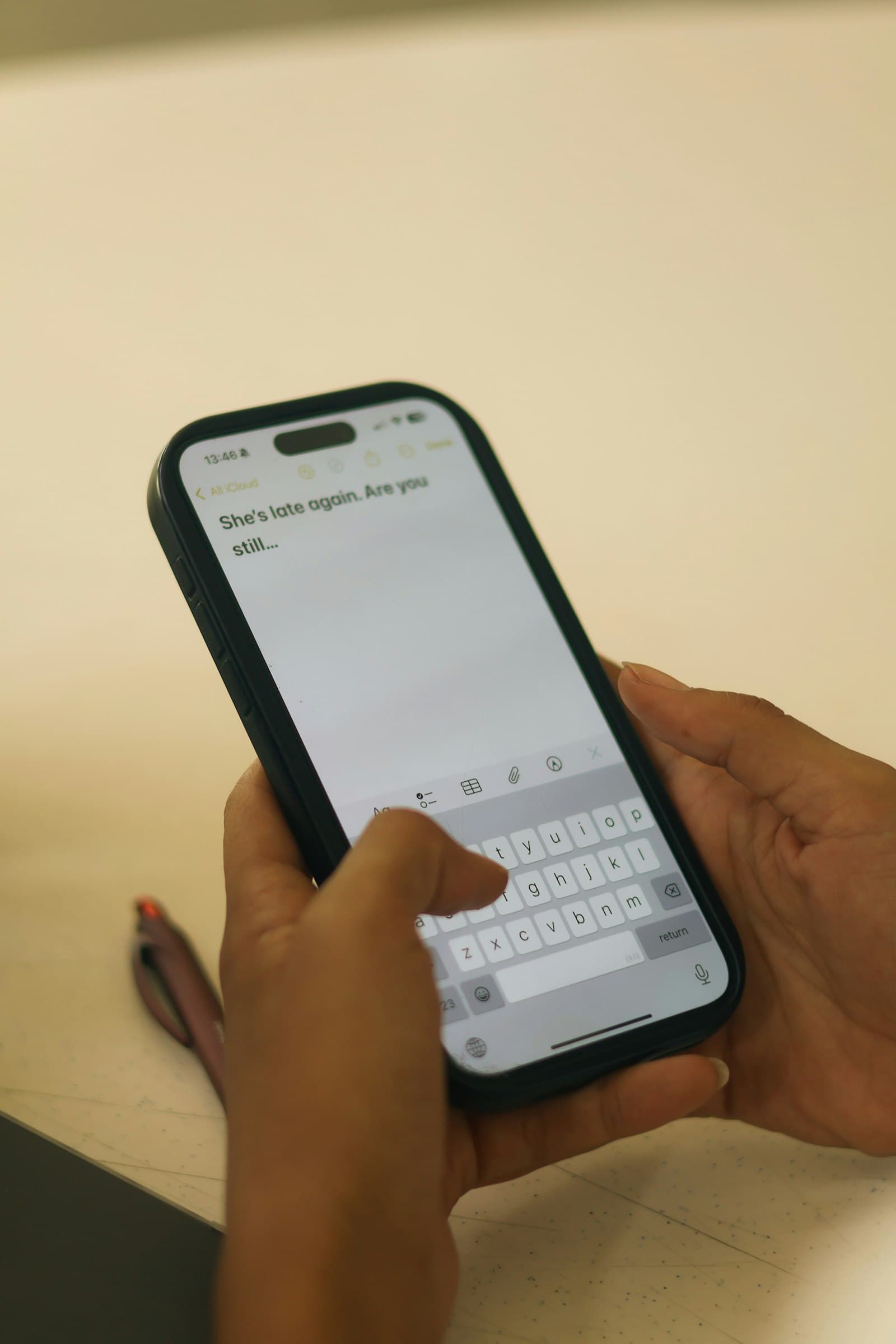 Hands typing on a smartphone with a text message visible on screen