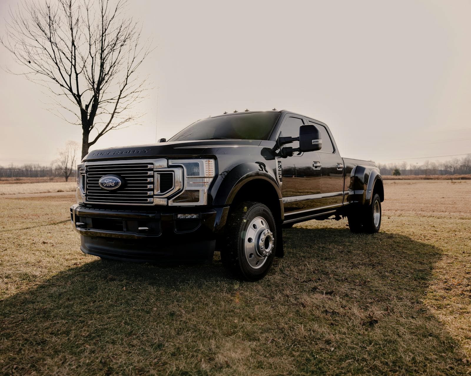 A heavy-duty work truck parked in a field under an overcast sky